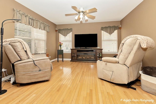 living room featuring a healthy amount of sunlight, hardwood / wood-style flooring, and a ceiling fan