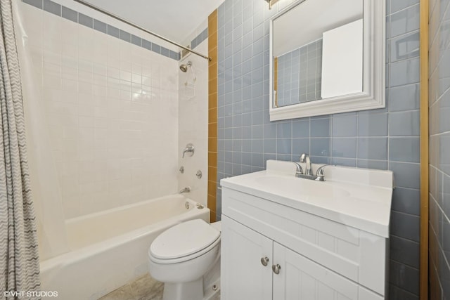 bathroom featuring toilet, shower / tub combo with curtain, tile walls, and vanity