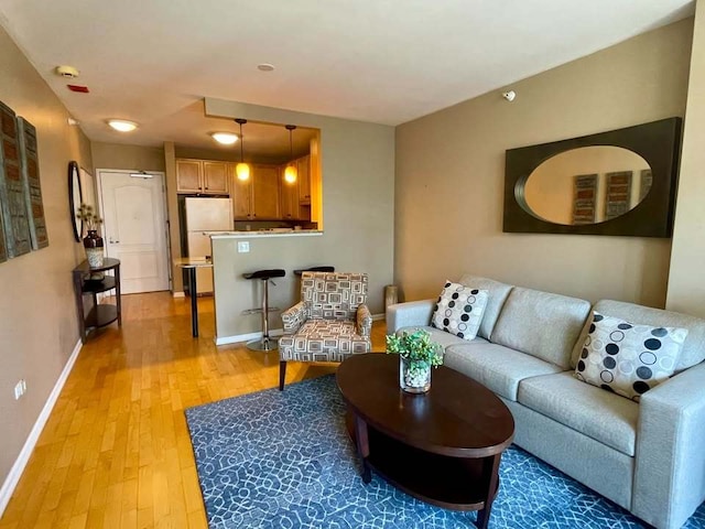 living area with light wood-type flooring and baseboards