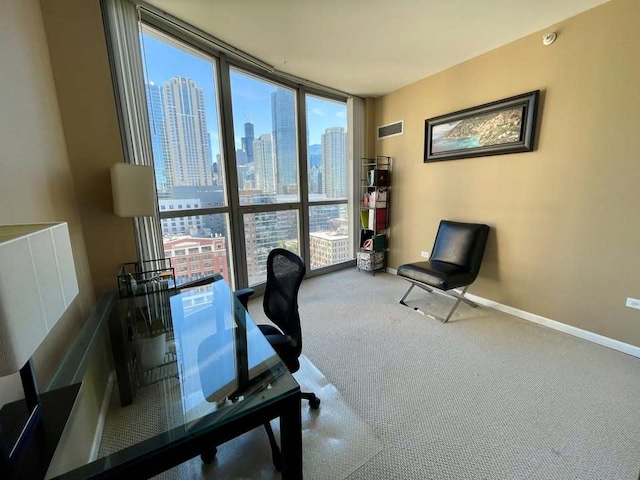 office featuring visible vents, baseboards, a city view, carpet floors, and floor to ceiling windows