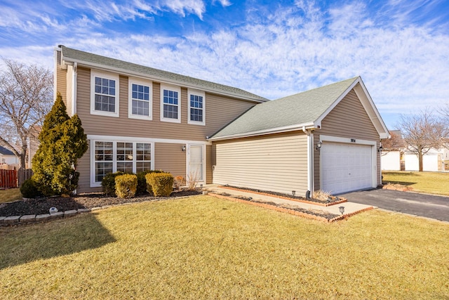 colonial inspired home with a garage, driveway, a front lawn, and a shingled roof