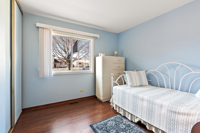 bedroom featuring visible vents, baseboards, and wood finished floors