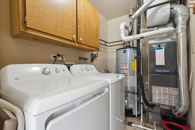 clothes washing area featuring cabinet space, washing machine and dryer, and gas water heater