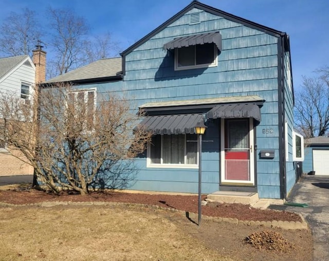 view of front of house with a detached garage and an outdoor structure