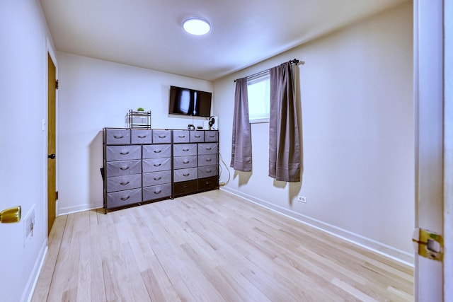 bedroom with light wood finished floors and baseboards