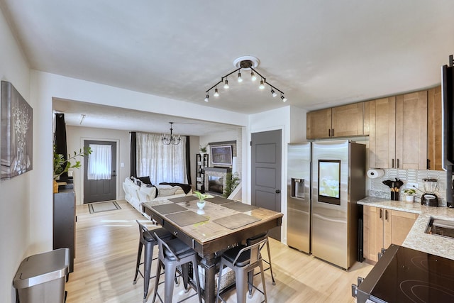 kitchen featuring tasteful backsplash, electric stove, stainless steel fridge with ice dispenser, and light wood finished floors