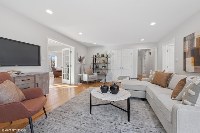 living room with light wood finished floors, recessed lighting, and french doors