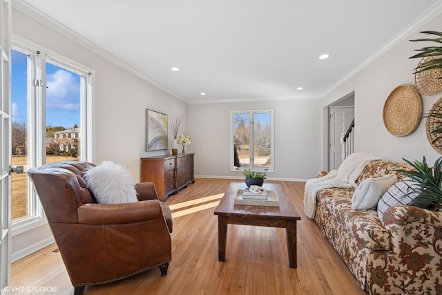 living room featuring plenty of natural light, light wood-style floors, and ornamental molding