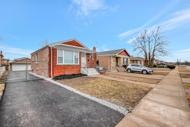 bungalow featuring brick siding and a detached garage