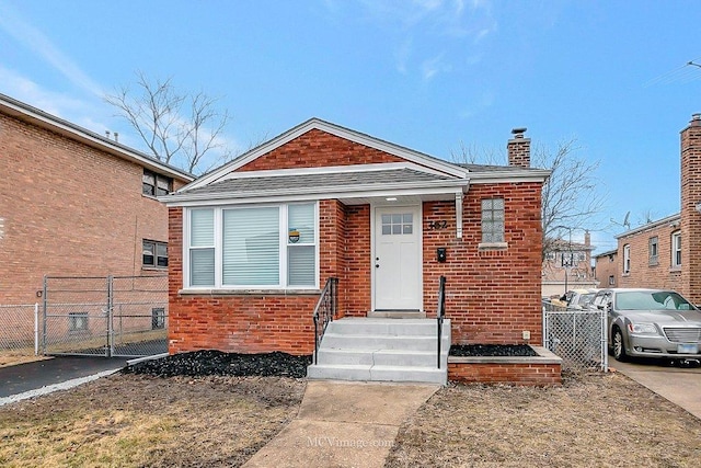 bungalow-style home with brick siding, a chimney, a shingled roof, a gate, and fence