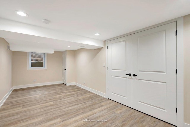 finished below grade area featuring light wood finished floors, baseboards, and recessed lighting