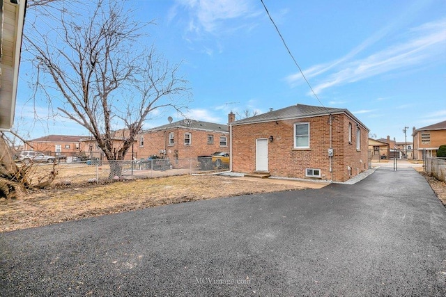 view of front of property with brick siding, a residential view, fence, and a gate