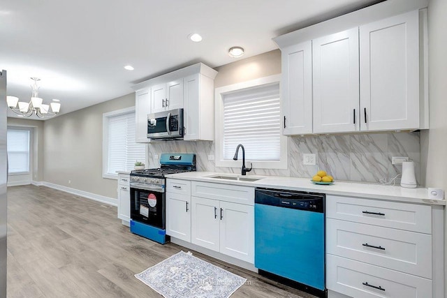 kitchen with light wood-style floors, decorative backsplash, stainless steel appliances, and a sink