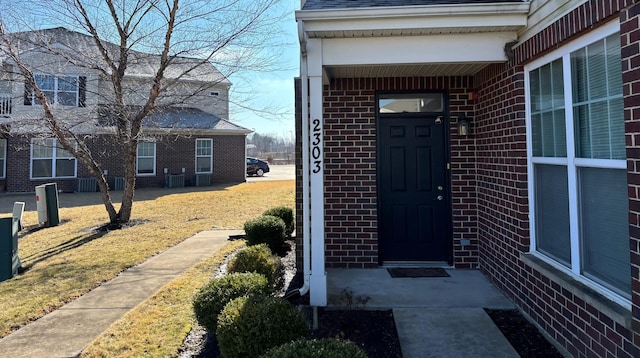 entrance to property featuring brick siding