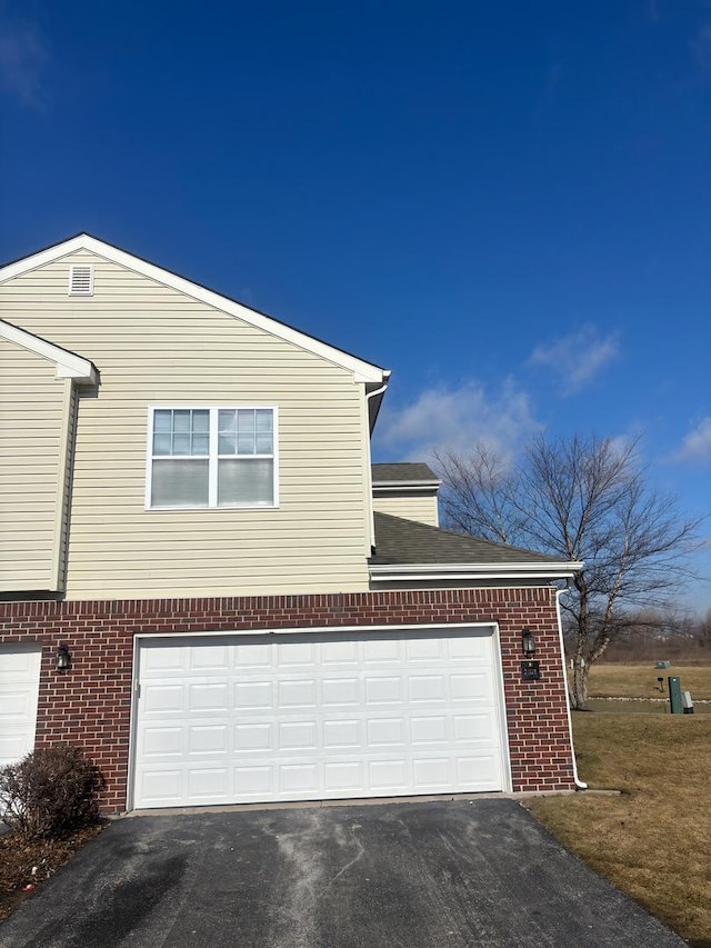 view of property exterior with a garage, brick siding, and aphalt driveway