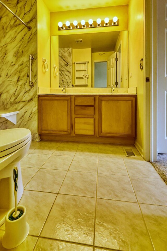 full bath featuring a sink, a shower, toilet, and tile patterned floors