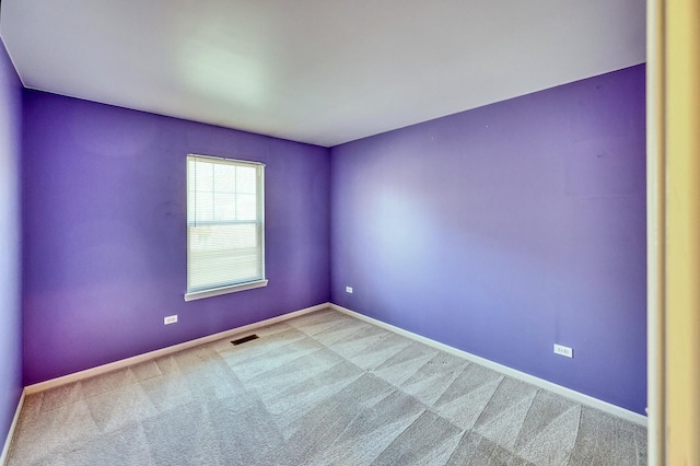 unfurnished room with carpet flooring, baseboards, and visible vents