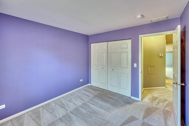 unfurnished bedroom with a closet, baseboards, visible vents, and carpet floors