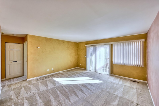 carpeted empty room with visible vents and baseboards