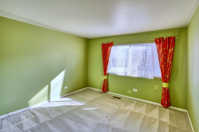 empty room with baseboards, carpet floors, and visible vents