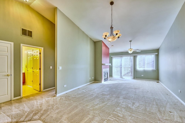 unfurnished room featuring ceiling fan with notable chandelier, carpet, visible vents, and high vaulted ceiling