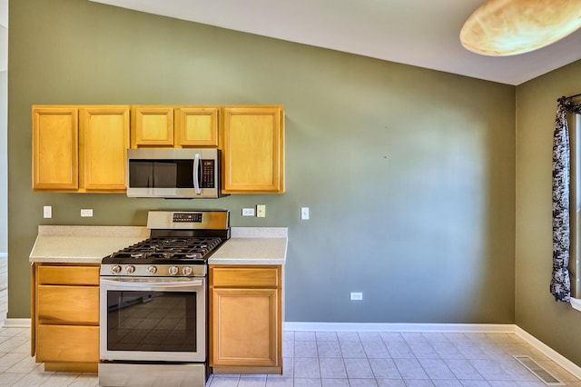 kitchen featuring visible vents, appliances with stainless steel finishes, light countertops, and baseboards