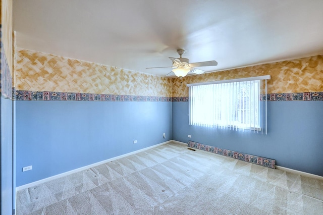 spare room featuring wallpapered walls, carpet flooring, baseboards, and ceiling fan