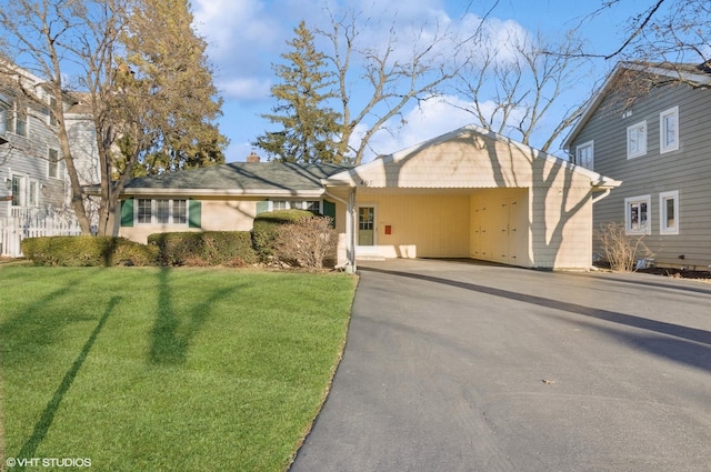 view of front of property with aphalt driveway, a front yard, and fence