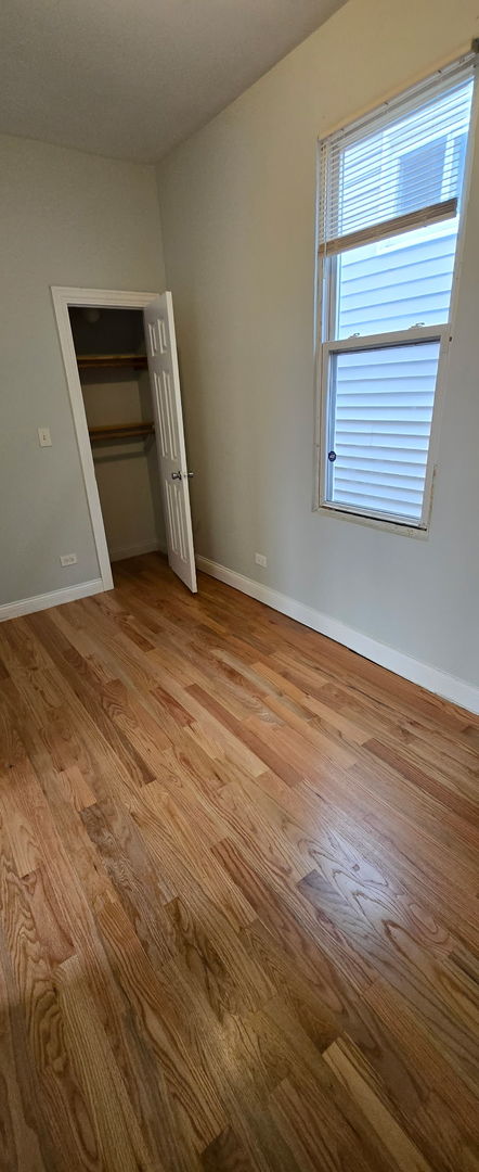 unfurnished bedroom featuring light wood-type flooring, a closet, and baseboards