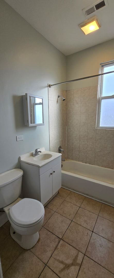 full bath with toilet, shower / bath combination, vanity, visible vents, and tile patterned floors