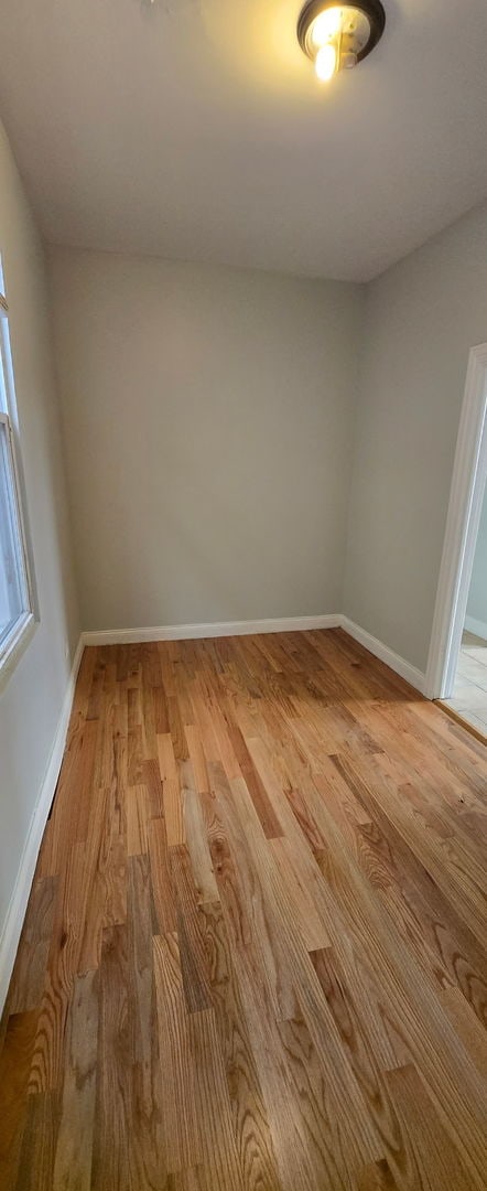 spare room with light wood finished floors and baseboards