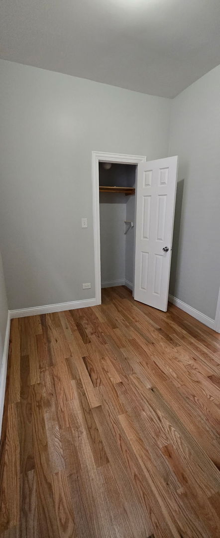 unfurnished bedroom with a closet, baseboards, and wood finished floors