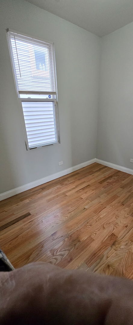 spare room featuring baseboards and wood finished floors