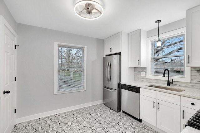 kitchen with baseboards, white cabinets, a sink, stainless steel appliances, and backsplash