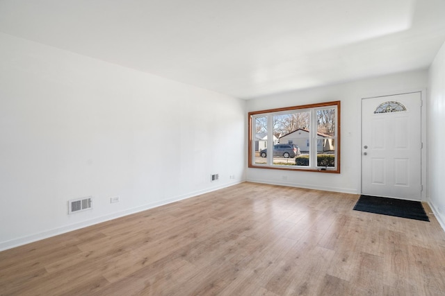 entryway featuring light wood finished floors, baseboards, and visible vents