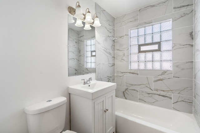 bathroom featuring toilet, shower / bathing tub combination, plenty of natural light, and vanity