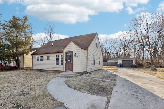 view of front of property with an outbuilding, a shingled roof, and a detached garage