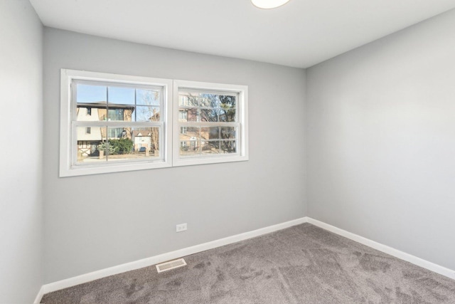 carpeted empty room with visible vents and baseboards