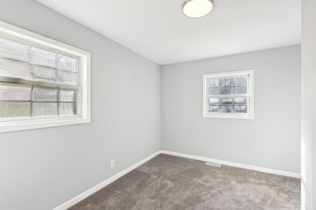 carpeted empty room with visible vents and baseboards