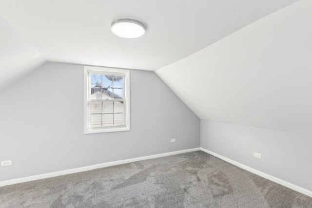 additional living space with lofted ceiling, carpet flooring, and baseboards