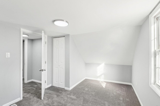 bonus room featuring carpet, vaulted ceiling, plenty of natural light, and baseboards