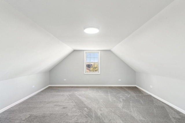 additional living space with carpet flooring, vaulted ceiling, and baseboards