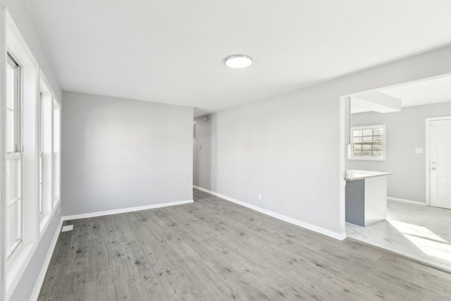 empty room with light wood-style flooring and baseboards