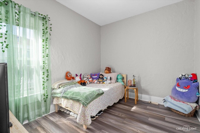 bedroom featuring wood finished floors and baseboards