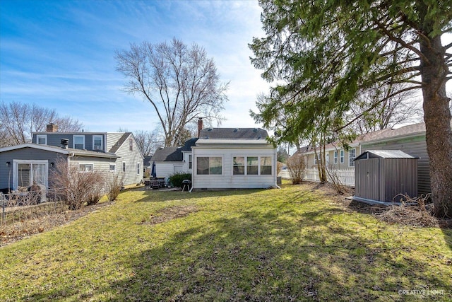 back of property featuring an outbuilding, a shed, a chimney, and a yard