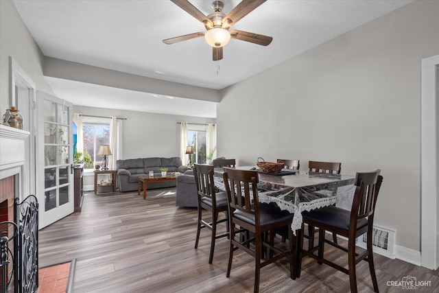 dining room featuring visible vents, plenty of natural light, and wood finished floors