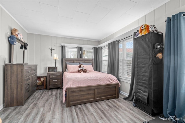 bedroom with baseboards, light wood-style floors, and ornamental molding