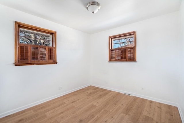 empty room with light wood-type flooring and baseboards