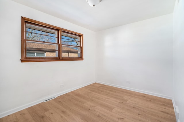 unfurnished room with baseboards, visible vents, and light wood-style floors