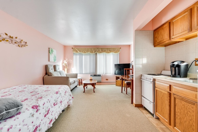 bedroom featuring a baseboard radiator, light colored carpet, and a sink